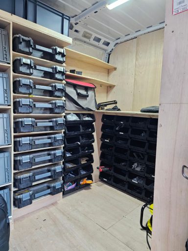 Interior of a van with organised shelves and containers for tools and equipment.